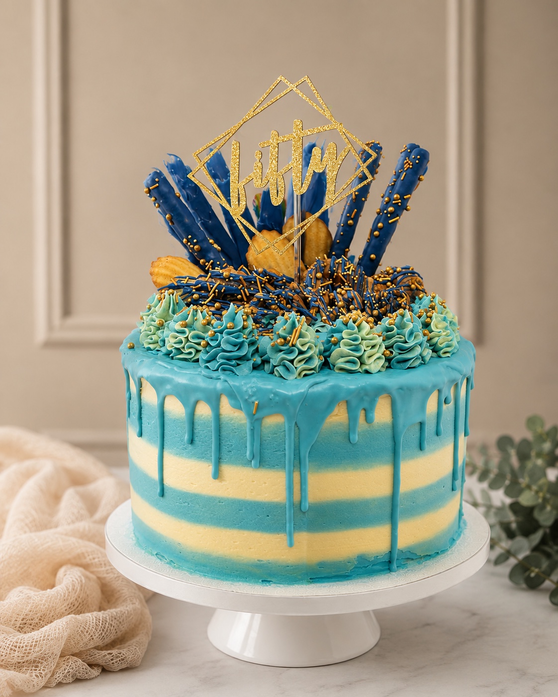 Blue and ivory 50th birthday drip cake with gold topper